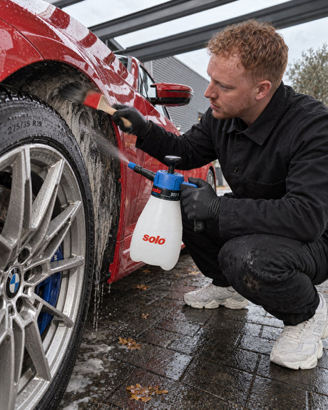 solo CLEANLine 303 B sprays cleaner into the wheel arch, Koch-Chemie brush cleans the arch lip on the BMW M2