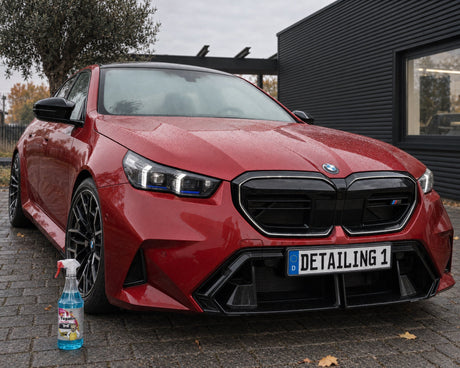 Tugalin Glas-Teufel in front of a red BMW M5 with a fogged-up windscreen — shown in the article “Car fogging up on the inside: why a clean windscreen stays clear for longer”