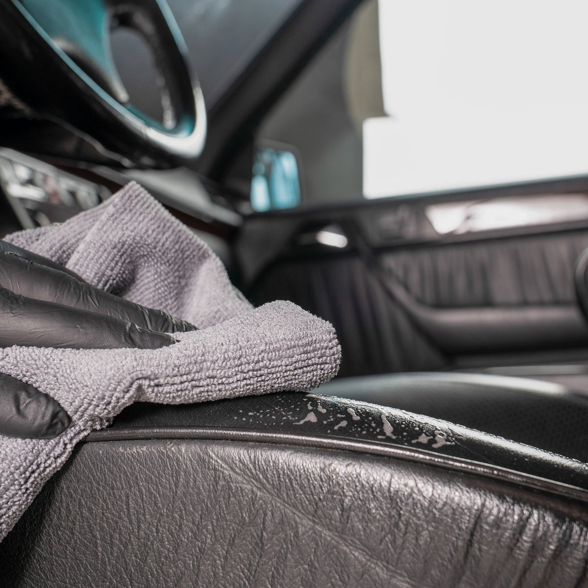 Detailing1 COLOURLOCK Leather Cleaner (Mild) — wiping down a black leather seat bolster with a microfibre towel