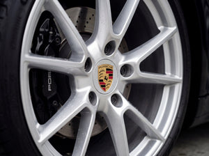 Saubere Porsche Alufelge mit polierten Speichen und zentralem Porsche Wappen nach Detailing-Reinigung ohne Bremsstaub oder Reiniger-Rückstände